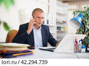 Office man is discussing the contract by phone in office. Стоковое фото, фотограф Яков Филимонов / Фотобанк Лори