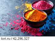 Holi background, colored powder on dark background with empty space for design. Стоковое AI-изображение, AI-художник Мария Фадеева / Фотобанк Лори