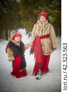 Teen and little girl in thick coat in cold winter day in forest. Medieval peasant sisters collecting firewood. Photoshoot in stile of Christmas fairy tale. Стоковое фото, фотограф Кривошеина Елена Леонидовна / Фотобанк Лори