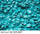 Wall texture with painted rubble. Coarse crushed stone painted turquoise creates a rough, textured backdrop. Стоковое фото, фотограф Бузмакова Светлана / Фотобанк Лори