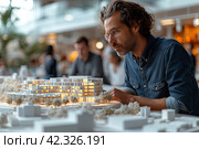 In an architectural office: a team of architects and engineers working on a building prototype design using a city model and computers running 3D CAD software. Residential or business area. Стоковое AI-изображение, AI-художник Ирина Михайличенко / Фотобанк Лори
