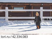 Portrait of a little boy in a yellow hat. The child runs through puddles on the farm, has fun and plays. It's a sunny day. Early spring. The first drop. Стоковое фото, фотограф Photojuli / Фотобанк Лори