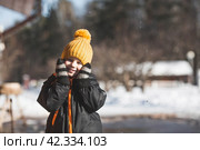 Portrait of a little boy in a yellow hat. The child runs through puddles on the farm, has fun and plays. It's a sunny day. Early spring. The first drop. Стоковое фото, фотограф Photojuli / Фотобанк Лори