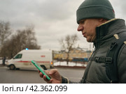 Мужчина держит в руке смартфон на улице города. Стоковое фото, фотограф YuryKara / Фотобанк Лори