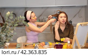 Adult woman curls hair of young woman. Стоковое видео, видеограф Яков Филимонов / Фотобанк Лори