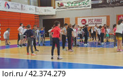 Sremska Mitrovica, Serbia 03.12.22: Children athletic competitions between school students. Strong boys and girls run, jump and play sports. Gym. Kids do warm-up, flexibility and agility exercises (2022 год). Редакционное видео, видеограф Юлия Петровская / Фотобанк Лори