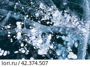 Beautiful natural winter ice texture with white bubbles and cracks in blue ice of frozen Baikal Lake in cold February day. Abstract bright textured background. Top view, mock up, flat lay, close-up. Стоковое фото, фотограф Виктория Катьянова / Фотобанк Лори