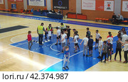 Sremska Mitrovica, Serbia 03.12.22: Children athletic competitions between school students. Boys and girls play sports. Gym. Kids stand in line for the long jump. Boy jumps. Coach records result (2022 год). Редакционное видео, видеограф Юлия Петровская / Фотобанк Лори