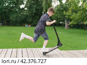 Moscow, Russia - July 26-2019 Trick at sportive push scooter in the park. Редакционное фото, фотограф YuryKara / Фотобанк Лори