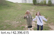 Two baby girls happy holding hands and running and rejoicing in the city park. Стоковое видео, видеограф Громов Александр / Фотобанк Лори