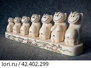 Семья пеликенов (улыбающиеся мифические существа). Скульптурная композиция из моржового бивня. Сувенир из клыка моржа. Традиционное чукотское искусство резьбы по кости. Уэленская косторезная мастерская, Уэлен, Чукотский полуостров, Россия. Редакционное фото, фотограф Андрей Степанов / Фотобанк Лори