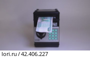 Hand of woman placing banknote into toy safe, symbolizing savings and smart budgeting concept. Стоковое видео, видеограф Андрей Знаменский / Фотобанк Лори