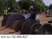 10 июля 2021г. Торжок, деревня Паника, Тверская область. Мотоциклисты на мотоциклах преодолевают препятствия на гоночной трассе. Мотокросс. Эндуро-кросс. Мотогонка с препятствиями. Соревнования Эндуро. July 10, 2021. Torzhok, the village of Panika, Tver region. Motorcyclists on motorcycles overcome obstacles on the race track. Motocross. Enduro-cross. Motorcycle race with obstacles. Редакционное фото, фотограф Мария / Фотобанк Лори