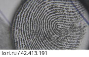 Fingerprints are investigated on fingerprint card. Macro shot. Стоковое видео, видеограф EStarodubov / Фотобанк Лори