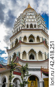 The high seven-tiered pagoda Ban Pa Thar of the Chinese Kek Lok Si Temple. On each floor there are columns, carved arches, curved roofs. A spire against a blue sky and clouds. Malaysia. Penang. (2023 год). Стоковое фото, фотограф Вера Ивановна Кубарева / Фотобанк Лори
