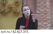 Mime imitates an imaginary eating food with a knife and fork. Стоковое видео, видеограф EStarodubov / Фотобанк Лори