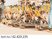 Много желтых электросамокатов Whoosh сваленных в кучу на улице города. Аренда самокатов (2021 год). Редакционное фото, фотограф Константин Григорьев / Фотобанк Лори