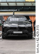 Lamborghini Urus parked on the street in Moscow. Black premium SUV supercar in front of office building. Редакционное фото, фотограф Константин Григорьев / Фотобанк Лори