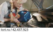 Автосервис. Attractive female mechanic carries out engine repairs in garage workshop. Стоковое видео, видеограф EStarodubov / Фотобанк Лори