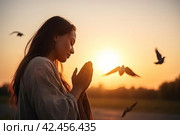 Woman praying sunset. Generate Ai. Стоковое AI-изображение, AI-художник Иван Рябоконь / Фотобанк Лори