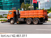 Orange water jetting truck is riding on the street. Water carrier car going to wash the asphalt road (2021 год). Редакционное фото, фотограф Константин Григорьев / Фотобанк Лори