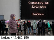 Люди стоят в очереди к стихийному мемориалу в память о погибших при теракте у здания концертного зала "Крокус сити холл", Московская область, Россия (2024 год). Редакционное фото, фотограф Николай Винокуров / Фотобанк Лори