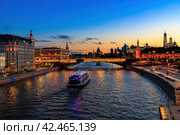 Cityscape of Moscow river scenery. Tourboat sails on the river in evening. Moscow Kremlin and Sofiyskaya embankment at night. Стоковое фото, фотограф Константин Григорьев / Фотобанк Лори