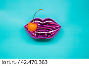 Shining pink lips and ripe yellow cherry on bright blue background, makeup and beauty concept. Стоковое фото, фотограф Александра Баранова / Фотобанк Лори