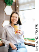 Smiling brunette girl in a cafe drinking a coffee. Стоковое фото, фотограф Александра Баранова / Фотобанк Лори
