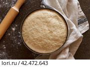 Raw yeast dough resting and rising in large metal bowl with linen towel. Стоковое фото, фотограф Natalia Gdovskaia / Фотобанк Лори