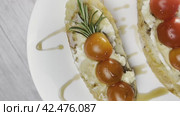 Sandwiches with cottage cheese and cucumber slices, cherry tomatoes on a white farm baguette on a wooden table. View from above. Стоковое видео, видеограф Ярославский Максим / Фотобанк Лори