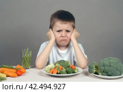 Fussy boy about vegetable dinner. Generate ai. Стоковое AI-изображение, AI-художник Иван Рябоконь / Фотобанк Лори