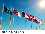 Flags different countries on high flagpoles. National flag different fluttering in wind. Flag Korea, Russia, United States, India, Vietnam, Cambodia and other against blue sky. Natural vertical photo. Стоковое AI-изображение, AI-художник Aleksandr Golubev / Фотобанк Лори
