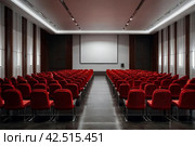Conference room with red chairs, interior lighting, and empty white insulated screen. Business meetings, conferences, trainings, used as template for elegant design. Interior of the conference hall. Стоковое AI-изображение, AI-художник Aleksandr Golubev / Фотобанк Лори