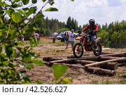 10 июля 2021г. Торжок, деревня Паника, Тверская область. Мотоциклисты на мотоциклах преодолевают препятствия на гоночной трассе. Мотокросс. Эндуро-кросс. Мотогонка с препятствиями. Соревнования Эндуро. July 10, 2021. Torzhok, the village of Panika, Tver region. Motorcyclists on motorcycles overcome obstacles on the race track. Motocross. Enduro-cross. Motorcycle race with obstacles. Стоковое фото, фотограф Мария / Фотобанк Лори