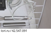 Suspension holder with hooks for utensils. Fixed to the closet. Utility hangs on hooks. Review of purchases. Vertical video. Close-up. Стоковое видео, видеограф Vadzim Yakubovich / Фотобанк Лори