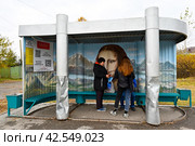 Заводоуковск. Пассажиры на автобусной остановка "Техникум" украшенная картиной Леонардо-да-Винчи Джокондой (2022 год). Редакционное фото, фотограф Александр Тараканов / Фотобанк Лори