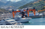 A drone surveys boats in the harbor with mountains in the background. Стоковое AI-видео, аниматор Юрий Поздников / Фотобанк Лори