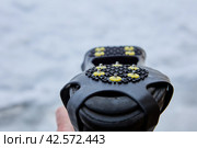 Traction on sidewalks of this over footwear rubber pad is provided by 10 small spikes, that digs into black ice and mixed snow. Стоковое фото, фотограф Владимир Григорьев / Фотобанк Лори