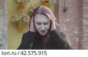 Воображаемая сильная головная боль Mime young woman holding her hands at her temples imitates an imaginary severe headache. Стоковое видео, видеограф EStarodubov / Фотобанк Лори