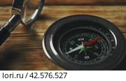 Close-Up of a Classic Compass Beside a Rope on a Wooden Surface During Daylight. Стоковое видео, видеограф Сергей Толмачёв / Фотобанк Лори