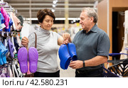 Elderly man and elderly woman choose slippers. Стоковое фото, фотограф Татьяна Яцевич / Фотобанк Лори