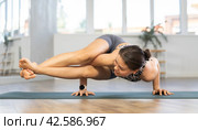 Young woman practicing vinyasa yoga in studio. Стоковое фото, фотограф Яков Филимонов / Фотобанк Лори