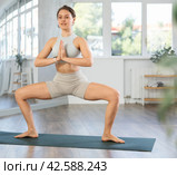 Girl performing Utkata Konasana with hands clasped in namaste. Стоковое фото, фотограф Яков Филимонов / Фотобанк Лори