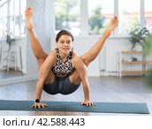 Young woman practicing vinyasa yoga in studio. Стоковое фото, фотограф Яков Филимонов / Фотобанк Лори