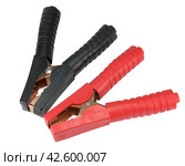 Красные и черные медные зажимы для подключения к аккумуляторной батарее. A big red clamps on a white background. Стоковое фото, фотограф Татьяна Д / Фотобанк Лори