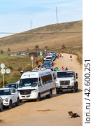 SAKHYURTA VILLAGE, BAIKAL LAKE, OLKHON ISLAND, IRKUTSK REGION, RUSSIA - August 14, 2023: A line of autotourists' cars at the ferry crossing from Olkhon Island after summer vacation. Редакционное фото, фотограф Виктория Катьянова / Фотобанк Лори