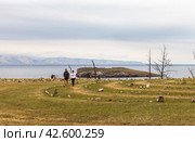 BAIKAL LAKE, OLKHON ISLAND, KHARANTSY VILLAGE, IRKUTSK REGION, RUSSIA - August 16, 2023: Couple of tourists walking around magical labyrinth of local attraction on shores of Small Sea. Редакционное фото, фотограф Виктория Катьянова / Фотобанк Лори