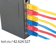 Сетевой коммутатор с подключенными разноцветными сетевыми кабелями. Closeup of network cables connected to router on white. Стоковое фото, фотограф Татьяна Д / Фотобанк Лори