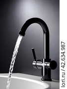 Modern black minimalist faucet with white sink in black bathroom. Стоковое AI-изображение, AI-художник Наталья Симакова / Фотобанк Лори